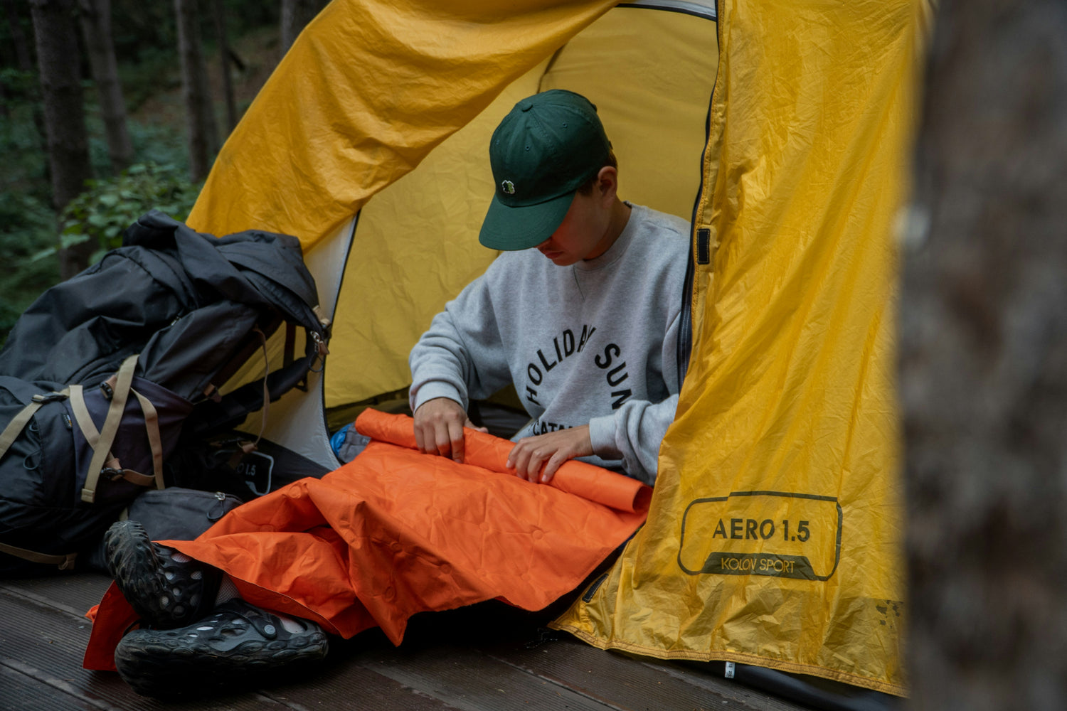 A young boy putting up a tent